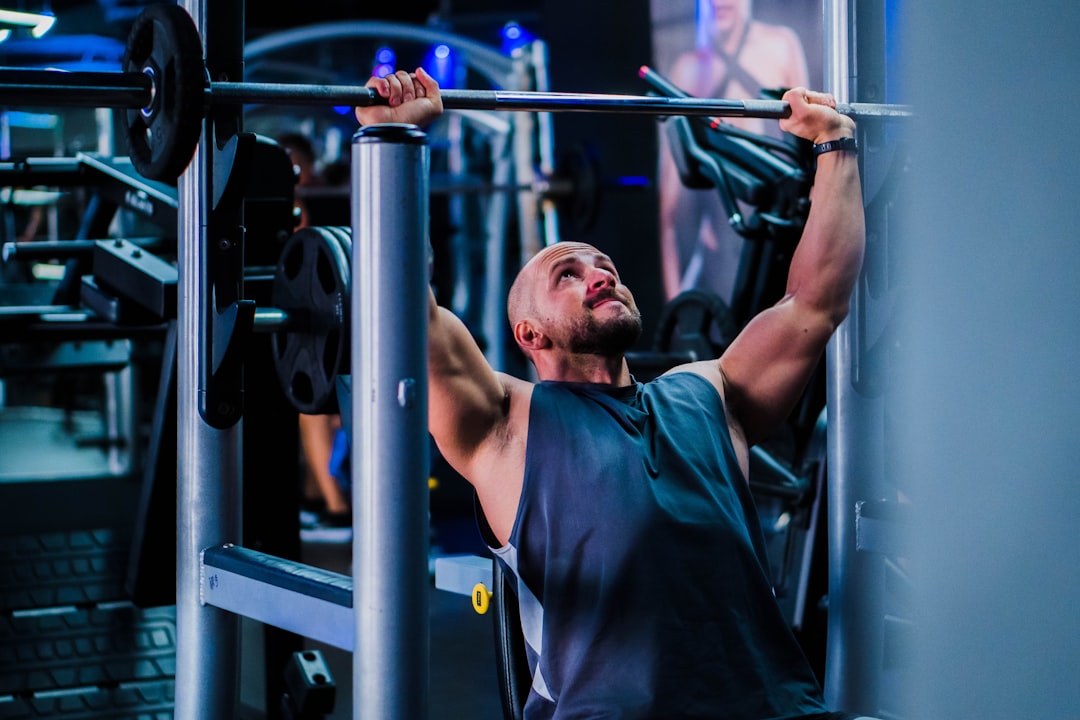 Person performing pull ups compound back exercise in gym