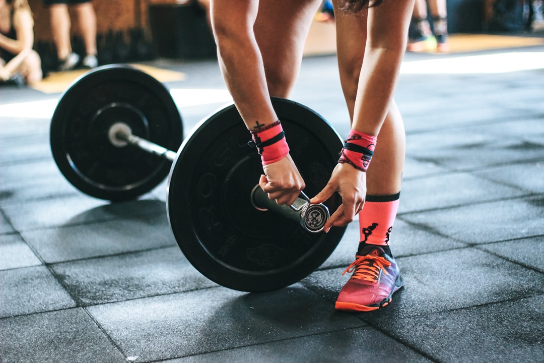 Person loading weight plates on barbell