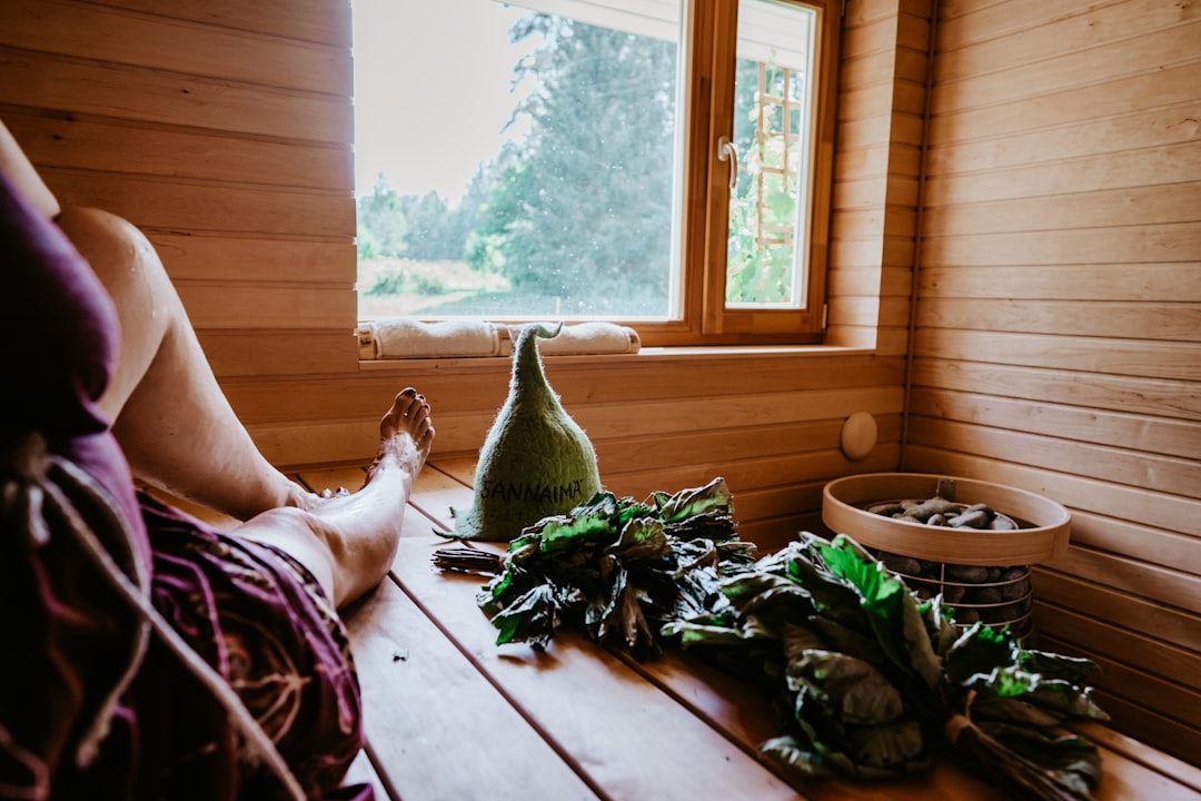 Person relaxing in sauna wellness recovery environment